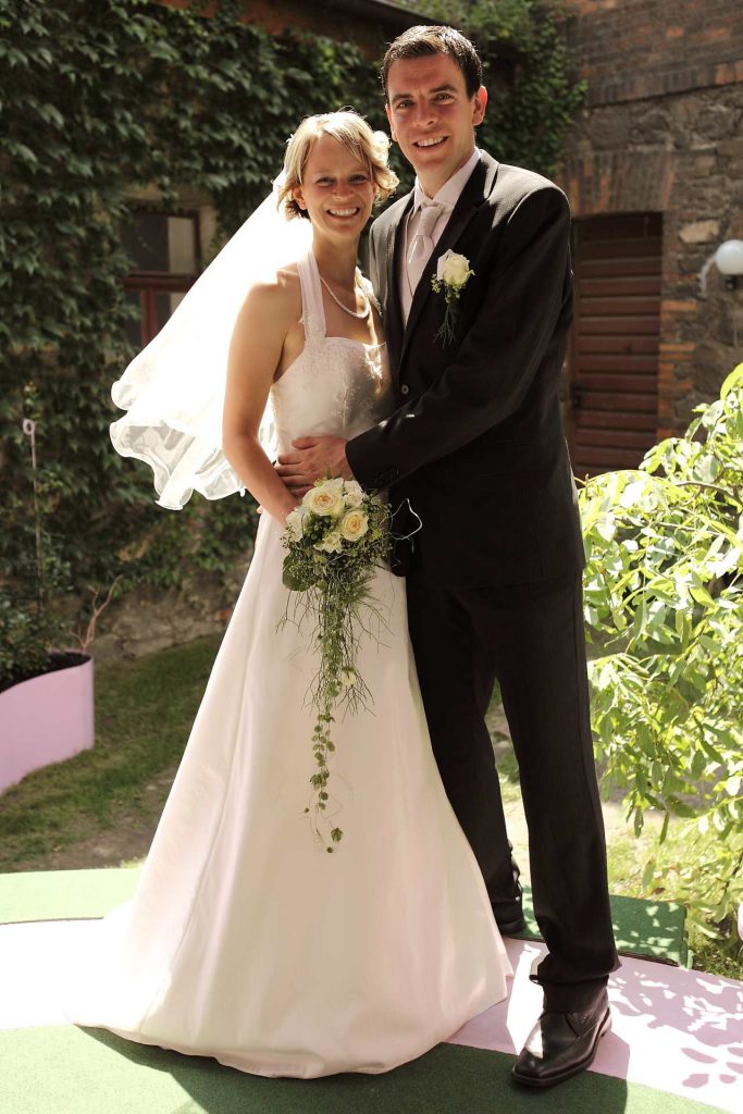 Elegante Hochzeit in Halle - Brautpaar lächelt stehend in Kamera