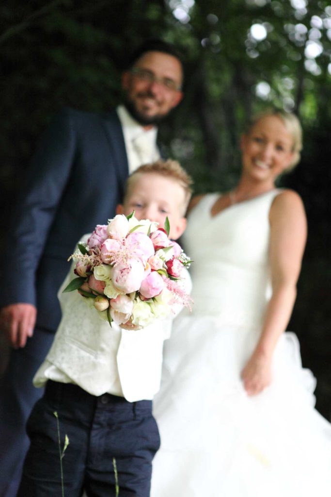 Hochzeitspaar mit Kind und Strauß