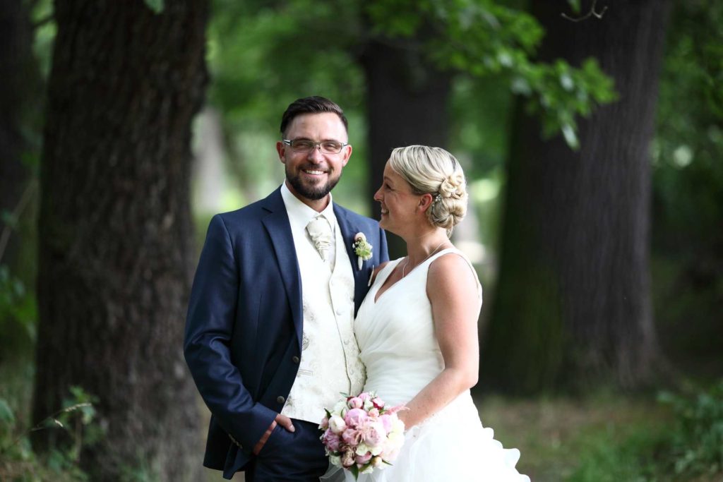 Hochzeitspaar - Bräutigam schaut in Kamera