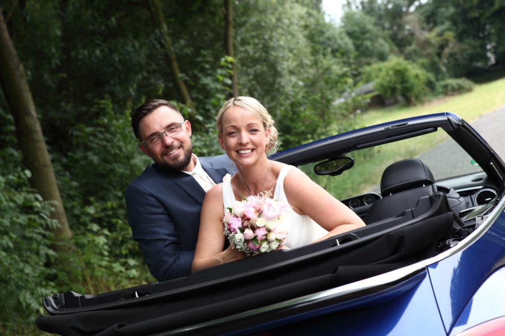 Hochzeitspaar im Auto