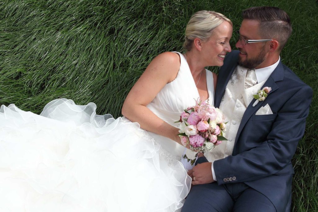 Hochzeitspaar auf grünem Gras
