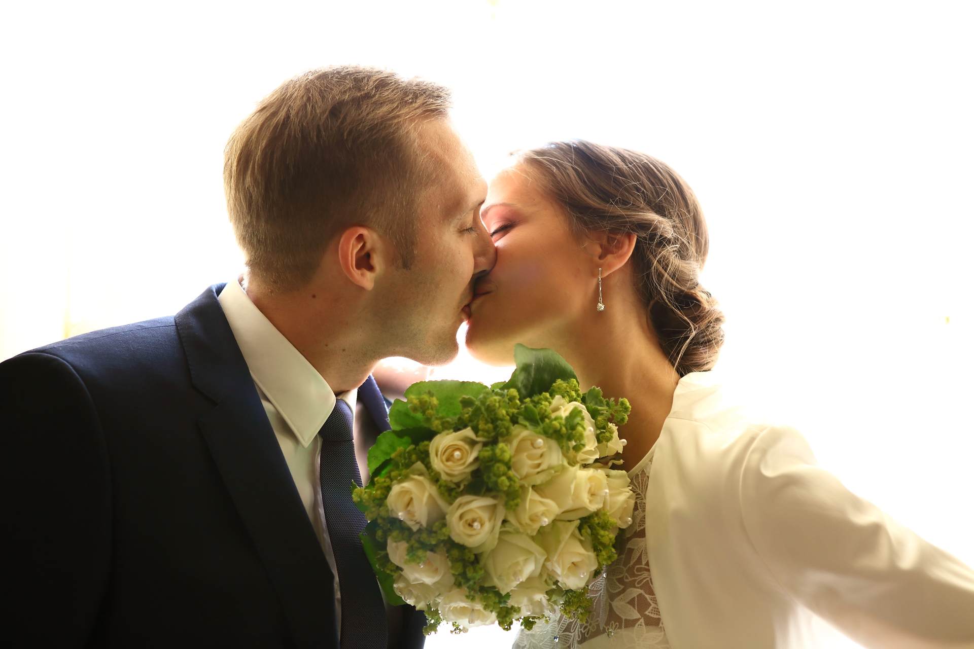 Hochzeitsfotos in Leipzig - Hochzeitspaar küsst sich vor dem Fenster
